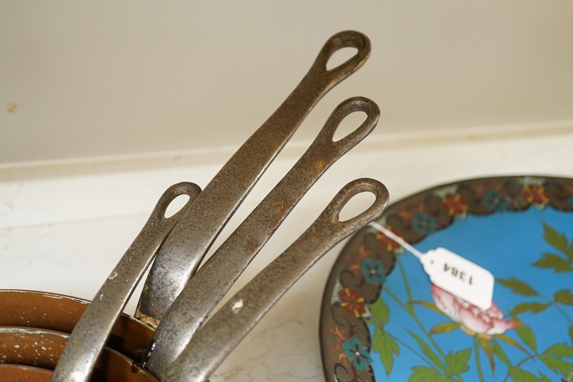 A graduated set of five copper saucepans